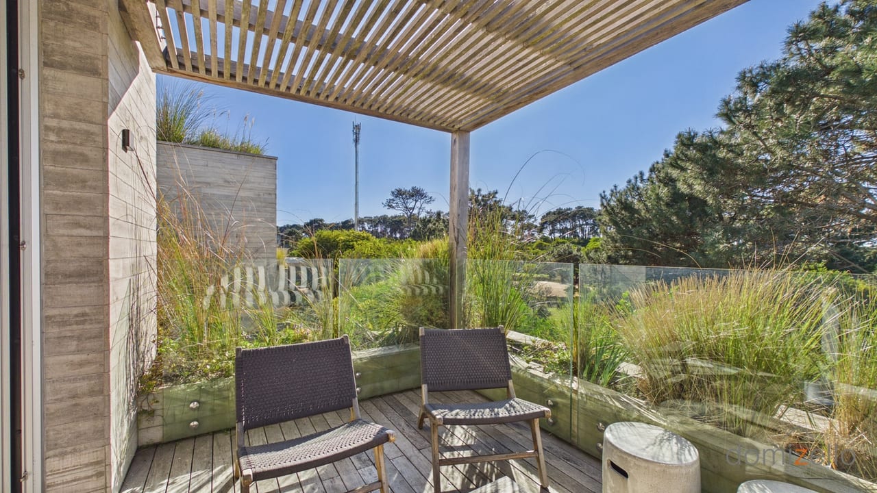 Terraza con pérgola y vista al jardín con vegetación, apartamento en Faro de José Ignacio, Maldonado