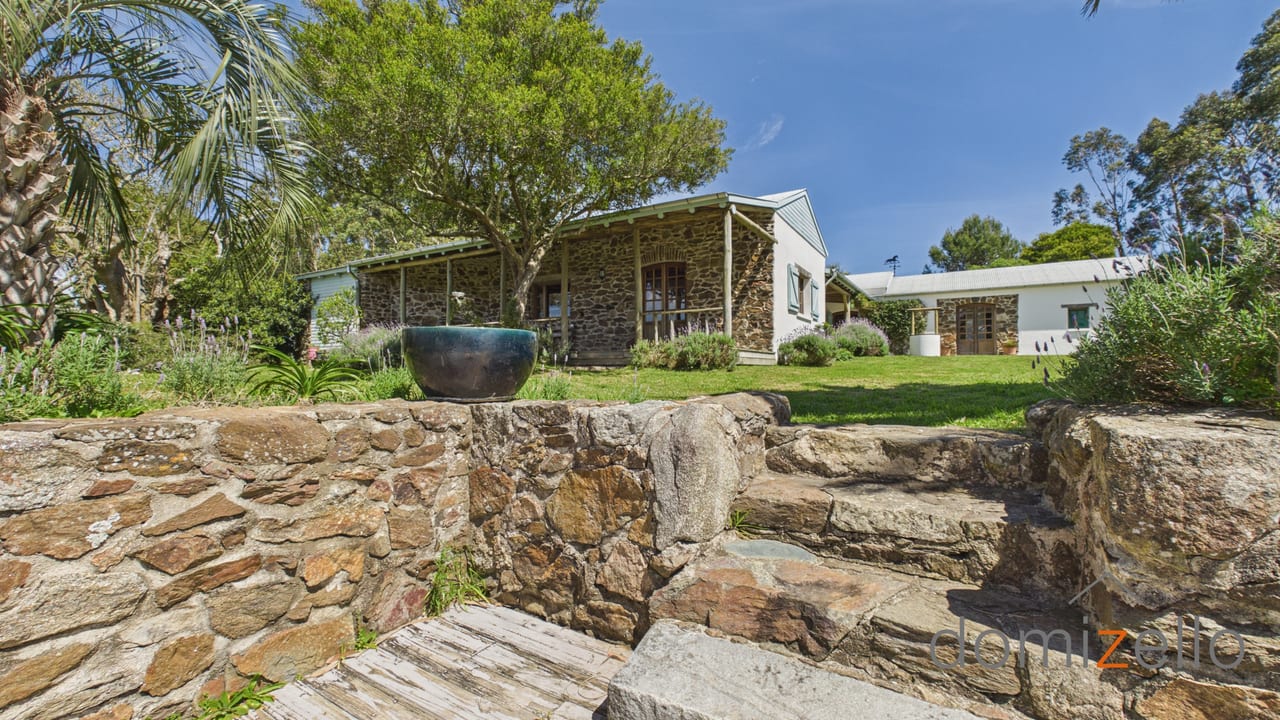 Casa de piedra con galería y jardín con muro de piedra, estancia en Rocha Rural, Rocha
