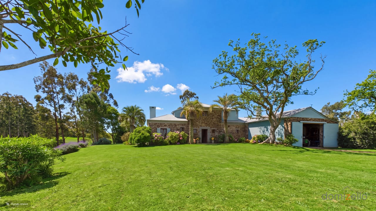 Stone facade of an estancia with a lawn, palm trees and a garage, rural Rocha, Rocha, Uruguay
