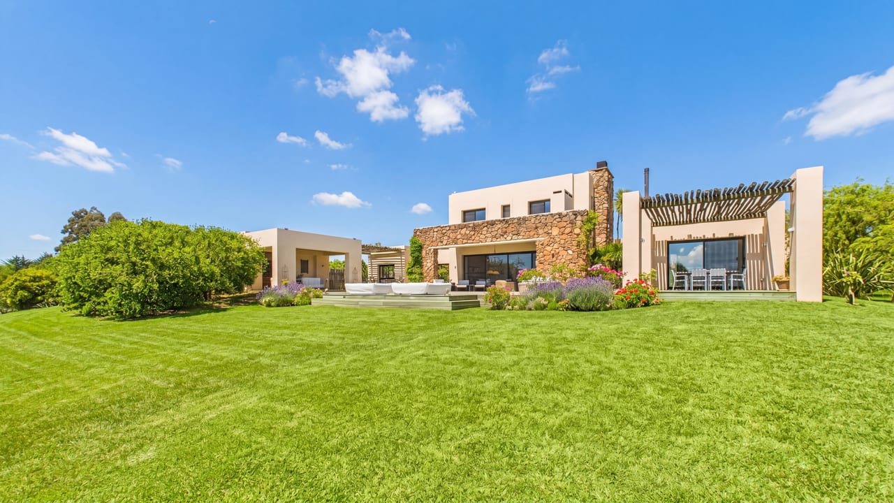 Modern house with stone and concrete, expansive terraces and lawn, residence in El Quijote, La Barra