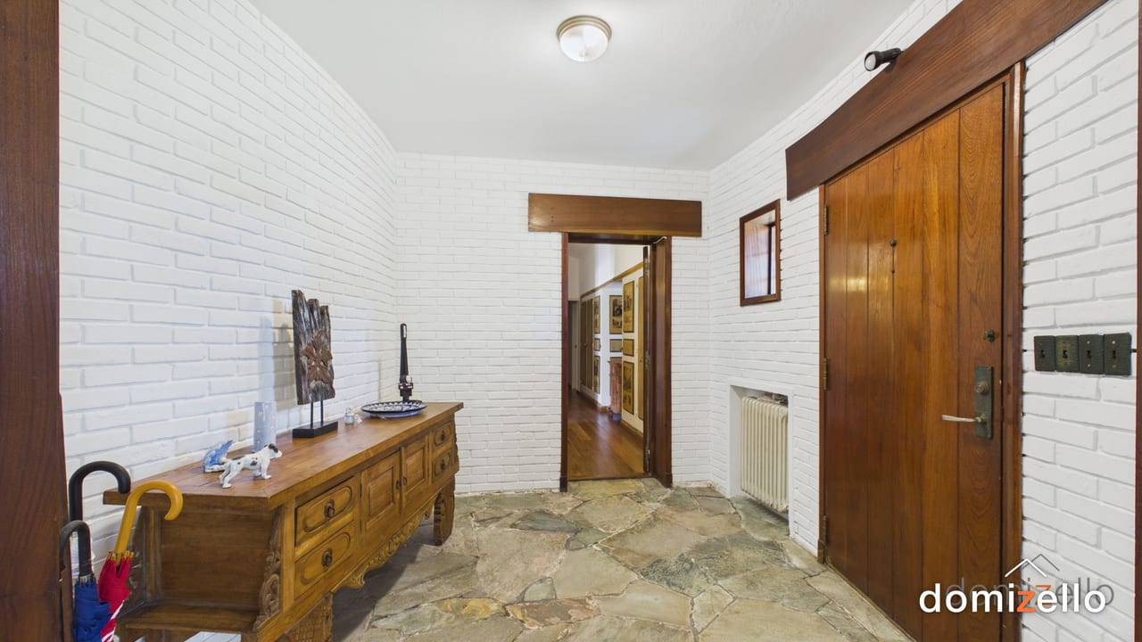 Hall de entrada con piso de piedra y paredes de ladrillo blanco, casa en Punta del Este, Maldonado